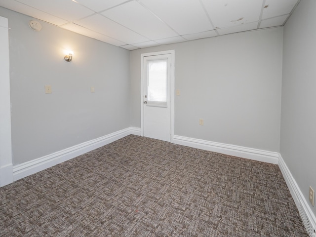 unfurnished room with carpet flooring, baseboards, and a paneled ceiling
