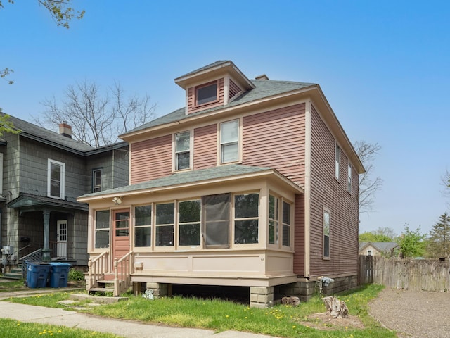 back of property with entry steps, fence, and a shingled roof