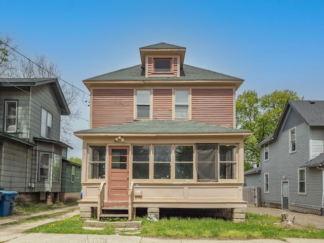 back of house featuring a sunroom and a shingled roof