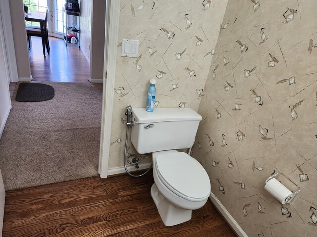 bathroom featuring toilet, baseboards, and wood finished floors