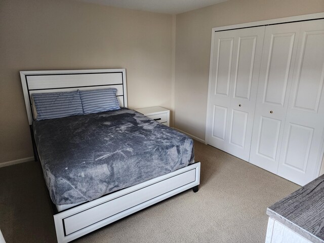 bedroom featuring carpet flooring, baseboards, and a closet