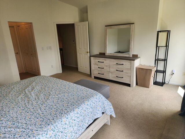 bedroom featuring baseboards, carpet flooring, and lofted ceiling