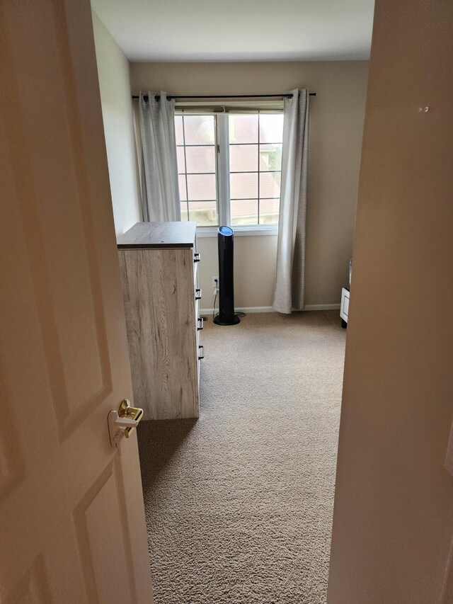carpeted empty room featuring baseboards