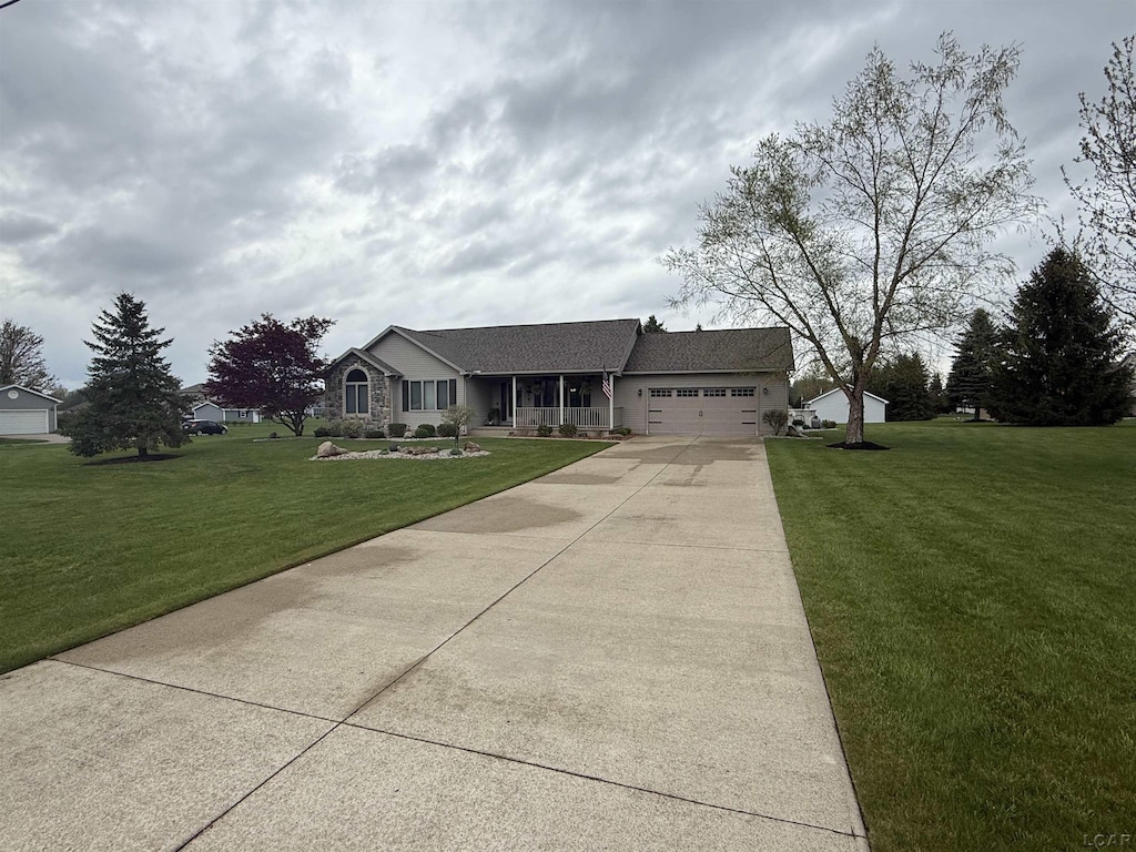 single story home featuring concrete driveway, an attached garage, and a front yard