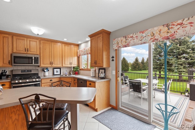 3136 Planeview Dr, Adrian, MI 49221 - kitchen with light countertops, backsplash, stainless steel appliances, and recessed lighting