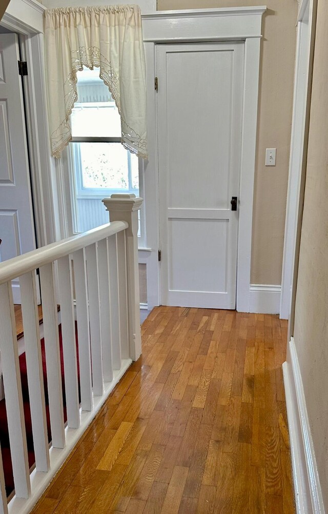 corridor with hardwood / wood-style flooring