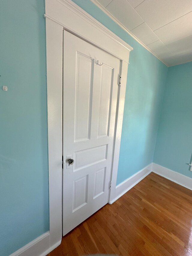 interior space with baseboards, ornamental molding, and wood finished floors