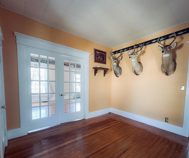 doorway featuring baseboards, french doors, and wood finished floors
