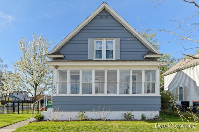 exterior space with a sunroom, a lawn, and fence