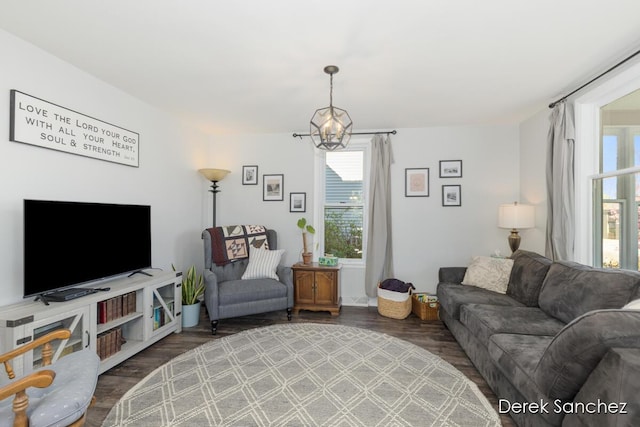 living area with an inviting chandelier, a wealth of natural light, and wood finished floors
