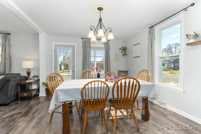dining area with visible vents, baseboards, wood finished floors, and an inviting chandelier
