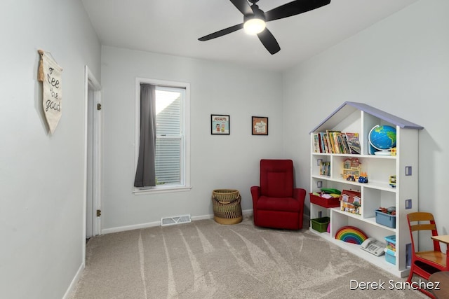living area with visible vents, carpet flooring, baseboards, and a ceiling fan