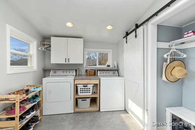 laundry area with cabinet space, washer and dryer, a barn door, recessed lighting, and light tile patterned floors