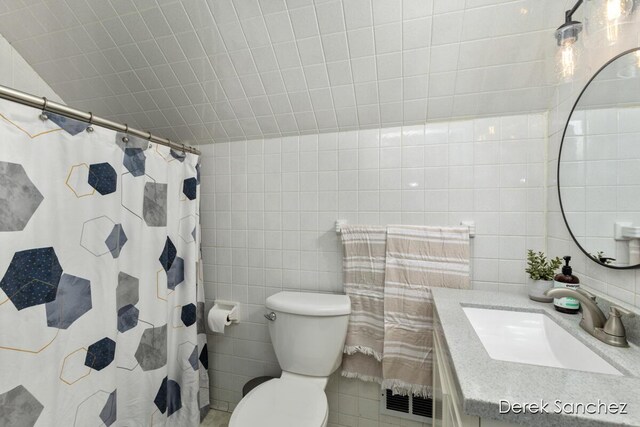 full bath with vanity, curtained shower, toilet, and tile walls
