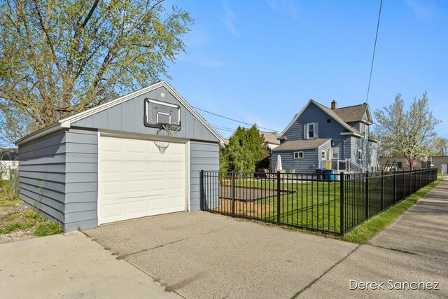detached garage featuring fence and driveway