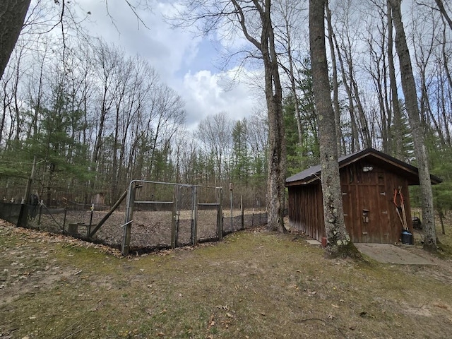 view of yard with a storage shed, fence, and an outdoor structure