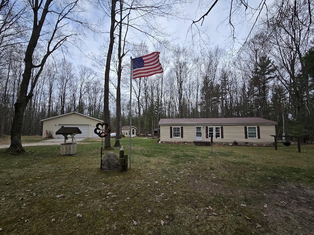 manufactured / mobile home featuring a detached garage, metal roof, and a front yard