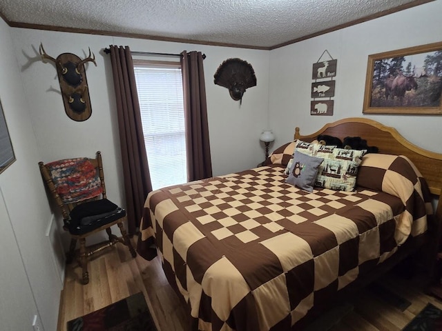 bedroom with ornamental molding, a textured ceiling, and wood finished floors