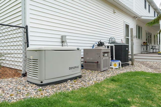 exterior details featuring a power unit, central AC, and fence