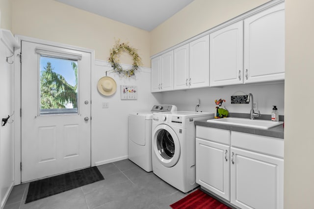 7572 S 10th St, Kalamazoo, MI 49009 - clothes washing area with cabinet space, a sink, baseboards, light tile patterned flooring, and washer and clothes dryer