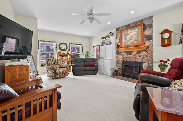 carpeted living room with recessed lighting, ceiling fan, and a stone fireplace