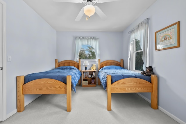 carpeted bedroom with baseboards, multiple windows, and ceiling fan