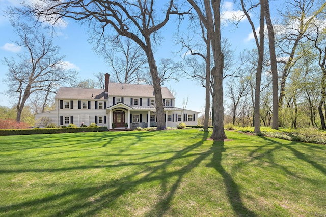 view of front of house featuring a front lawn and a chimney