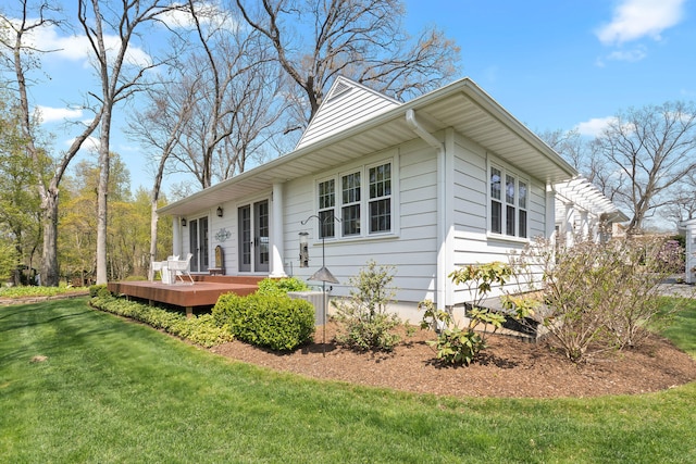 exterior space featuring a wooden deck and a front lawn