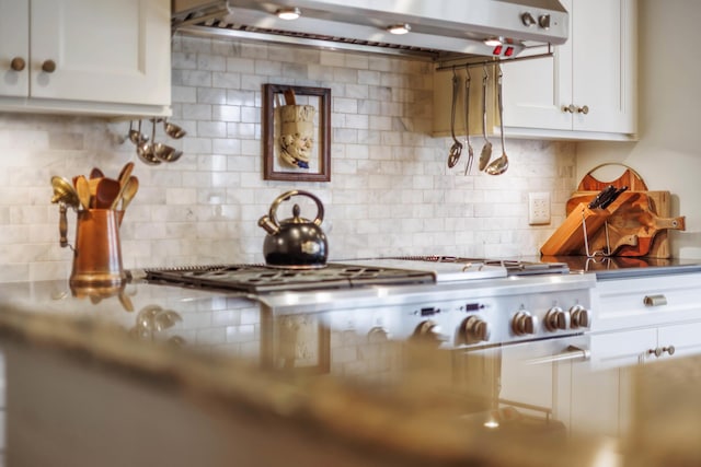 kitchen with exhaust hood, tasteful backsplash, and white cabinetry