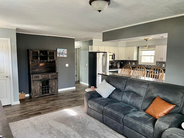 living area featuring baseboards, ornamental molding, a textured ceiling, and dark wood-style flooring