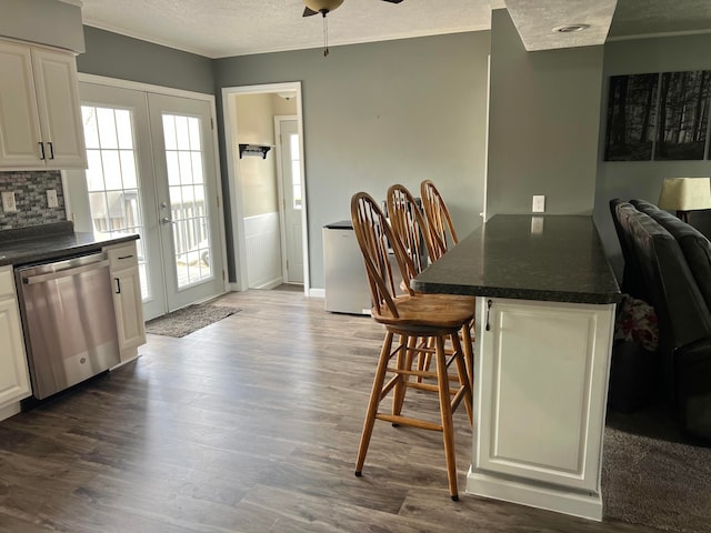 dining area featuring a healthy amount of sunlight, ceiling fan, dark wood-type flooring, a textured ceiling, and french doors
