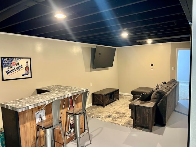 interior space featuring recessed lighting, baseboards, and a bar