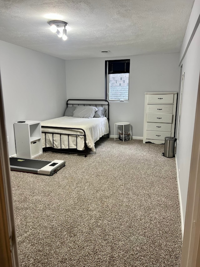 carpeted bedroom featuring a textured ceiling and baseboards