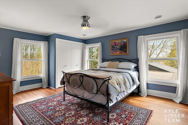 2630 Reeds Lake Ct SE, Grand Rapids, MI 49506 - bedroom with light wood-style flooring, a closet, baseboards, and ceiling fan