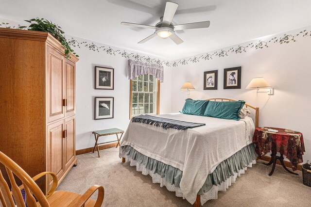bedroom with baseboards, a ceiling fan, and light carpet