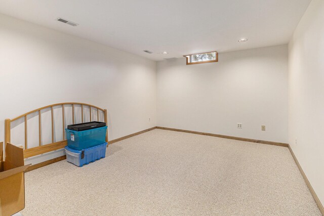 below grade area featuring recessed lighting, baseboards, visible vents, and carpet