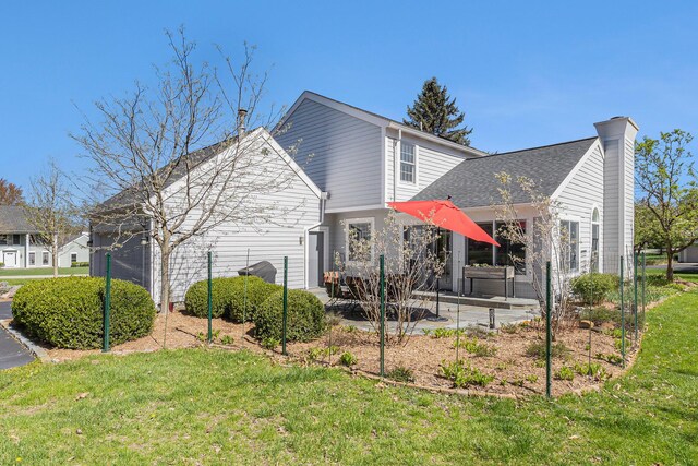 view of property exterior with a lawn, a chimney, and a patio area
