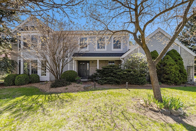 traditional-style house with brick siding and a front lawn