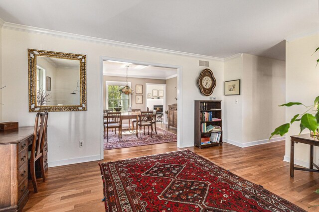 hall featuring ornamental molding, wood finished floors, and visible vents