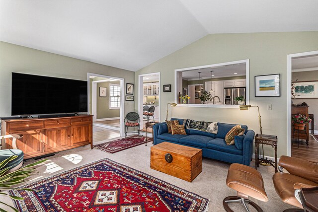 living room featuring lofted ceiling and light carpet