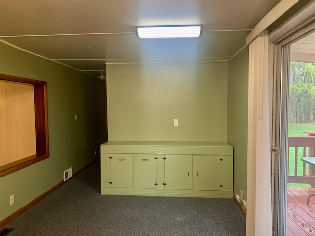 carpeted empty room featuring baseboards and visible vents