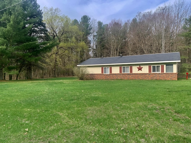 view of front facade with brick siding and a front lawn