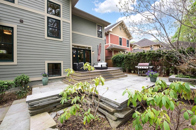 rear view of property featuring a patio area, fence, and a wooden deck