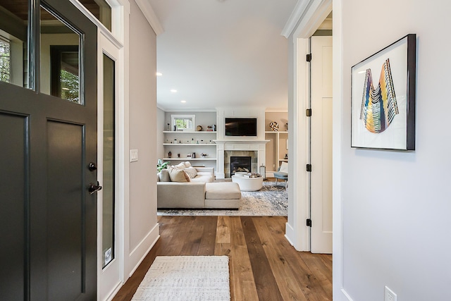 foyer entrance featuring recessed lighting, baseboards, a tiled fireplace, and dark wood-type flooring