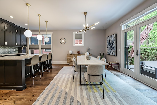 dining room featuring visible vents, wood finished floors, baseboards, recessed lighting, and a chandelier