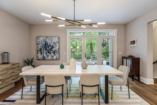 dining area with an inviting chandelier, baseboards, and wood finished floors