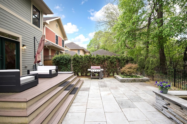 view of patio / terrace featuring outdoor lounge area, a wooden deck, a fenced backyard, and a grill