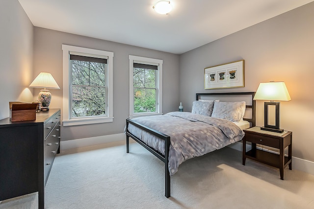 bedroom with baseboards and light carpet