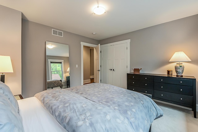 bedroom featuring carpet flooring, visible vents, and a closet