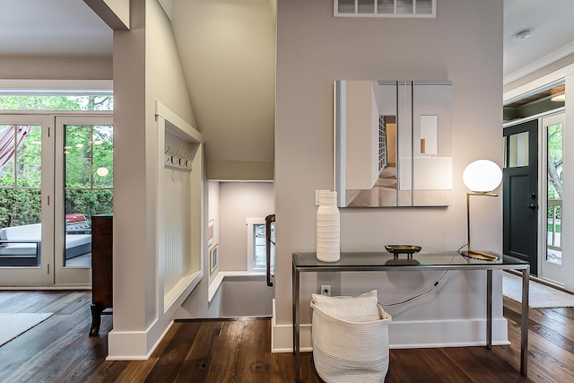 foyer entrance with baseboards, wood finished floors, and visible vents